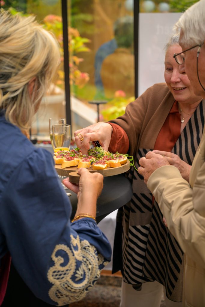 Guests sharing bites from a tray at the reception after the concert