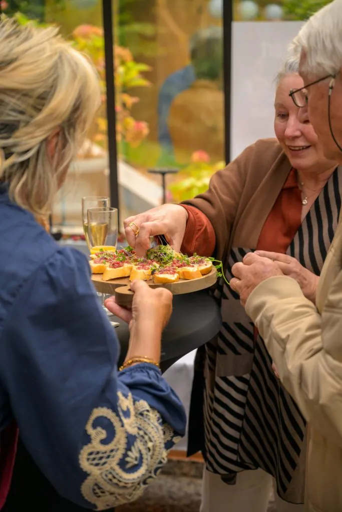 Guests sharing bites from a tray at the reception after the concert