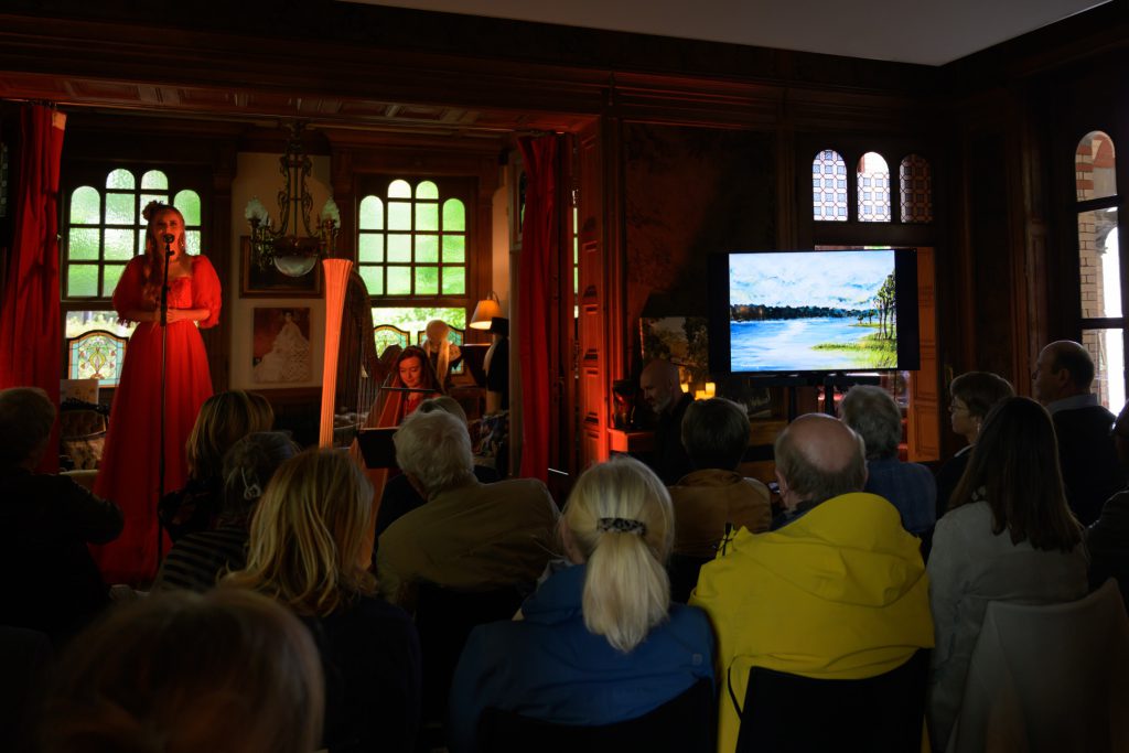 The Sirelia concert in the main hall, the chosen painting on a screen beside the performers