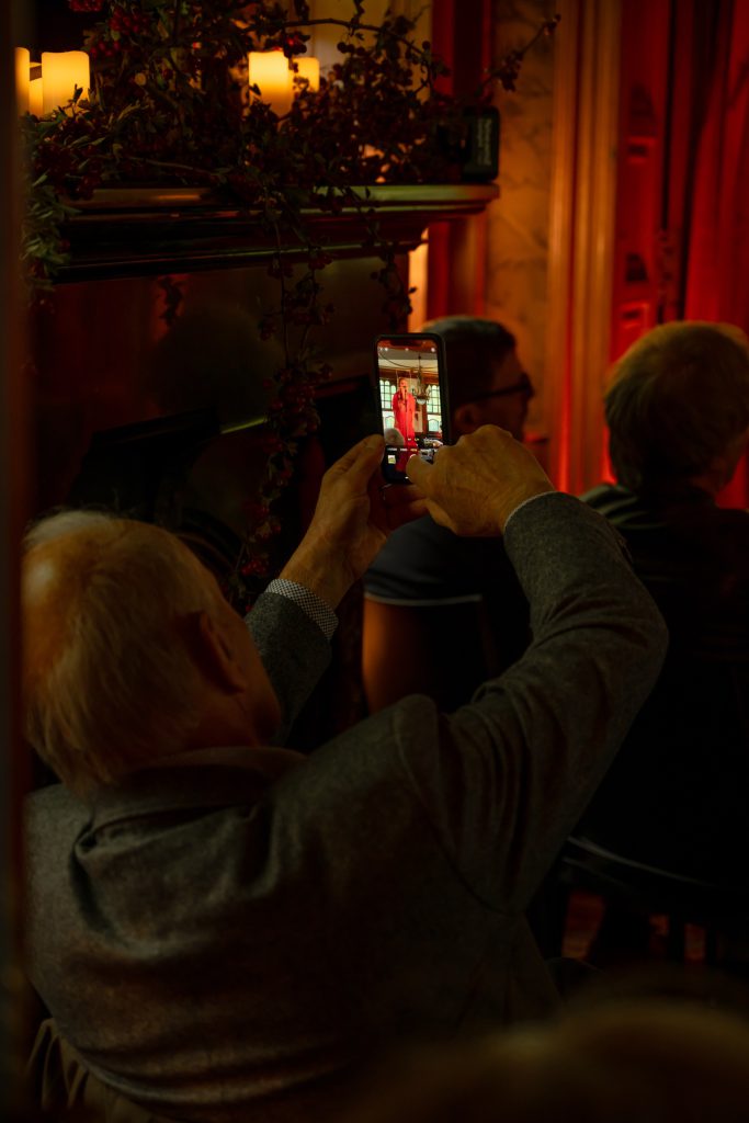 A guest filming the singer on her phone during the concert