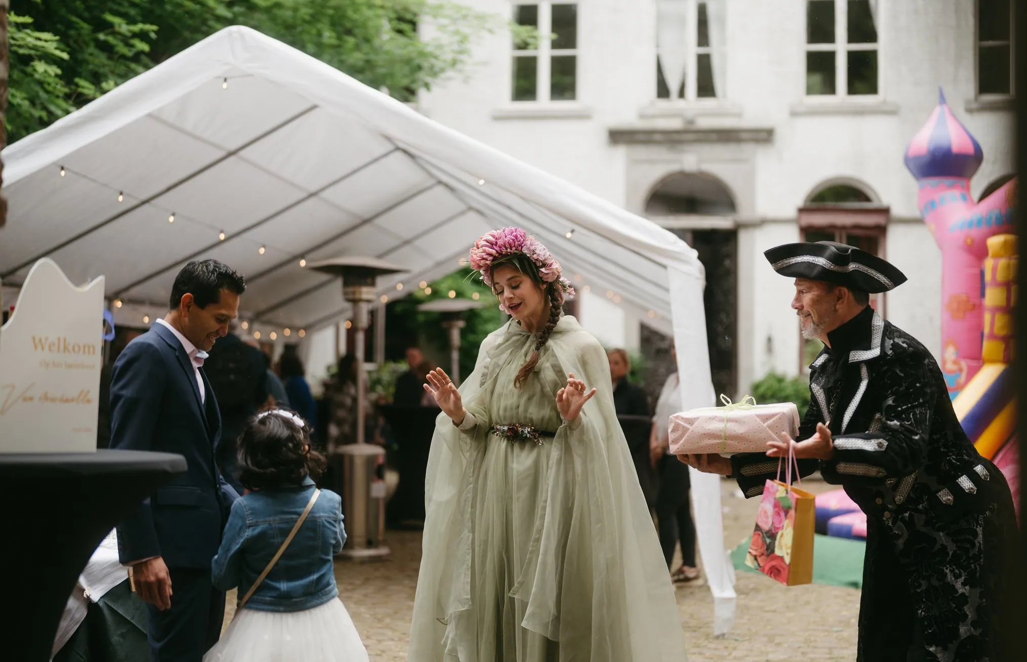 A performer in costume welcoming guests at an outdoor celebration