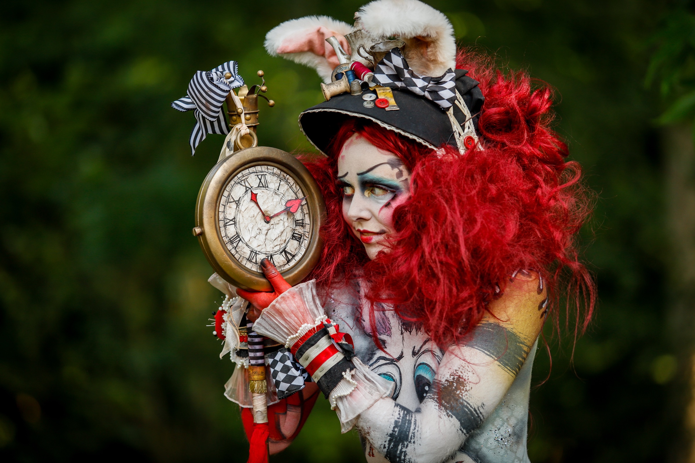 The White Rabbit in red curls and a checked top hat, holding a pocket watch